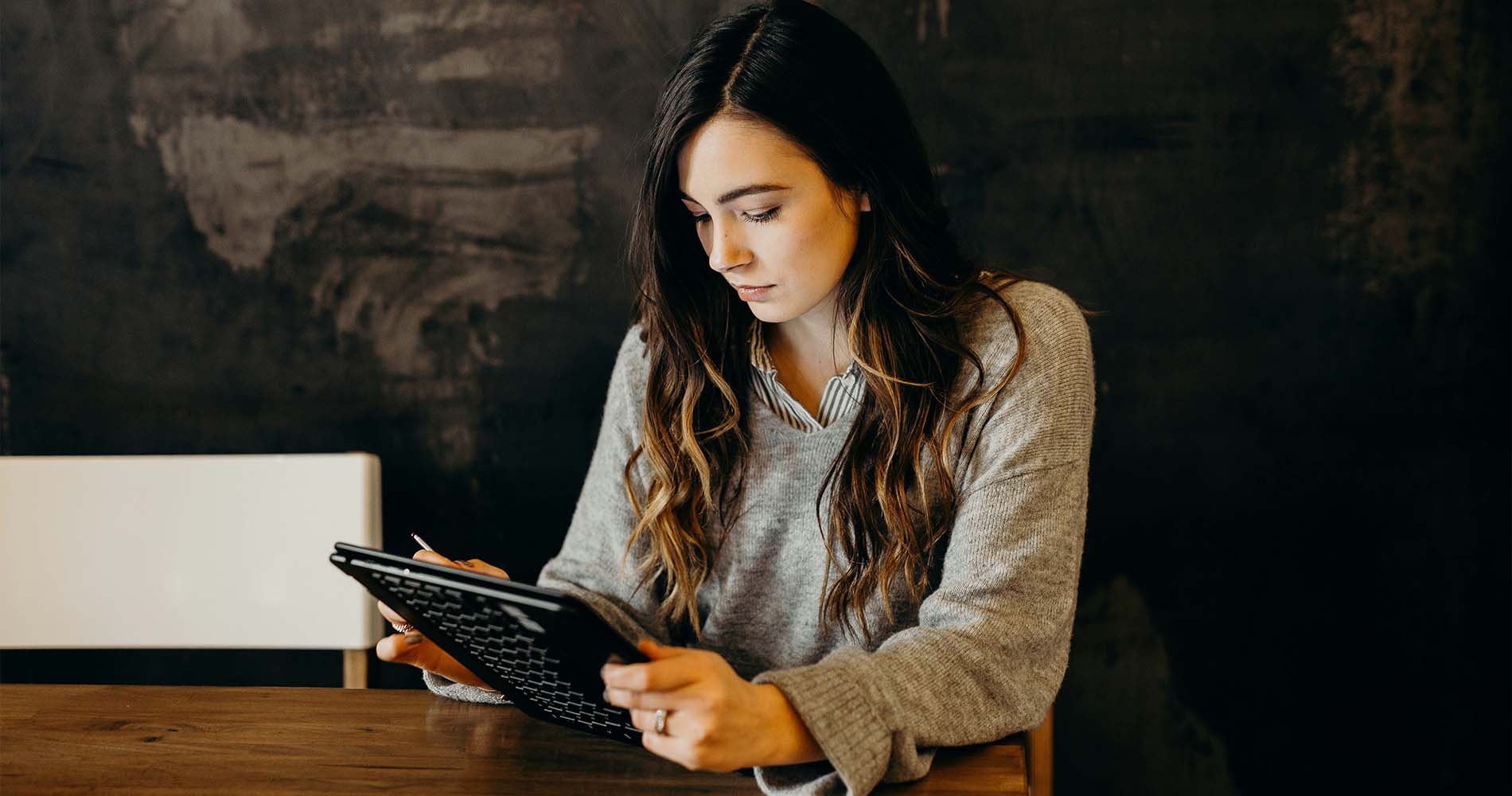 Junge Frau arbeitet konzentriert mit Tablet – ein typischer Arbeitsalltag in BWL Berufen wie dem Account Manager.