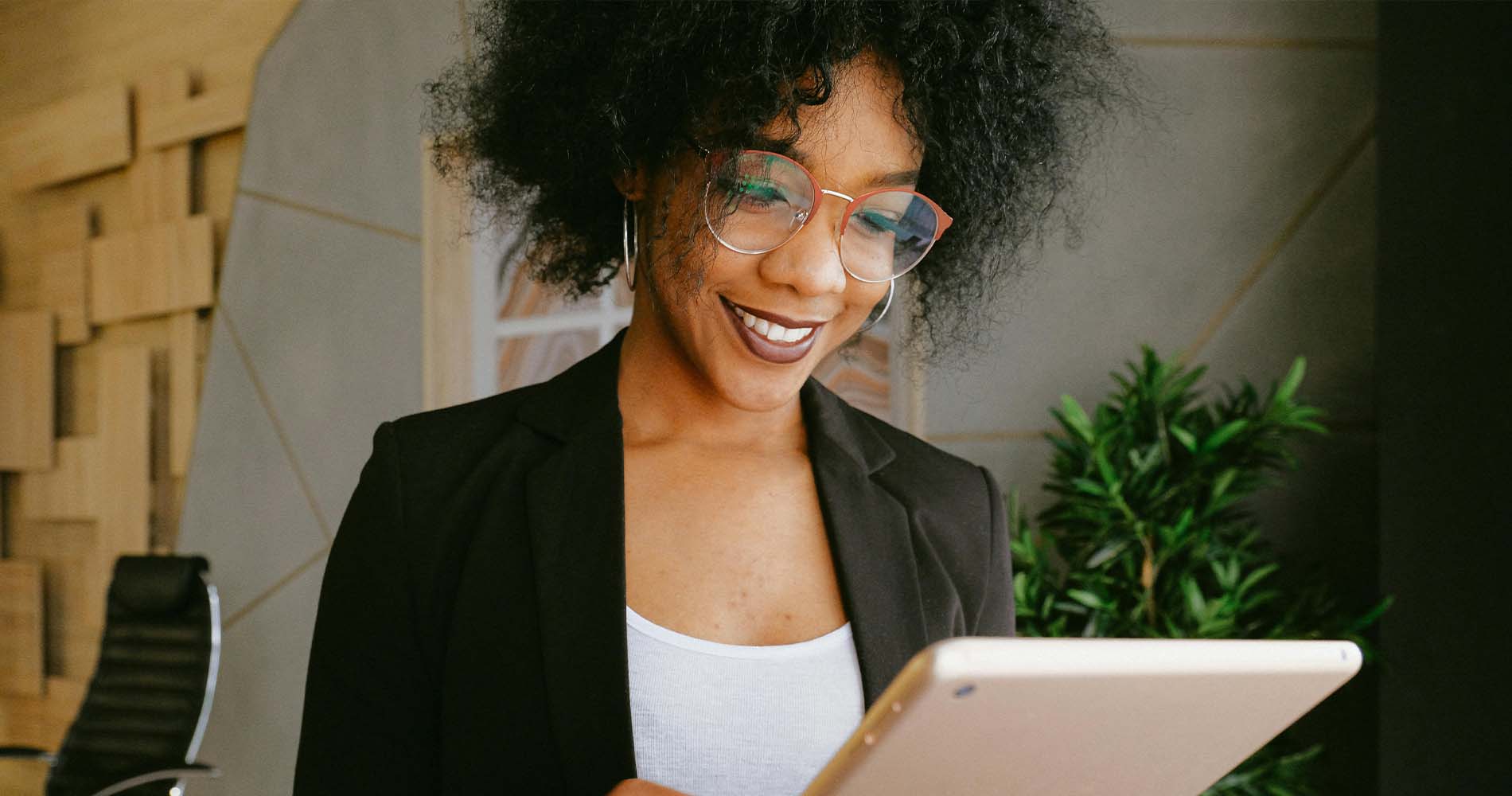 Junge Frau mit Tablet im Büro – steht sinnbildlich für BWL Berufe wie den Brand Manager im Bereich Markenführung.