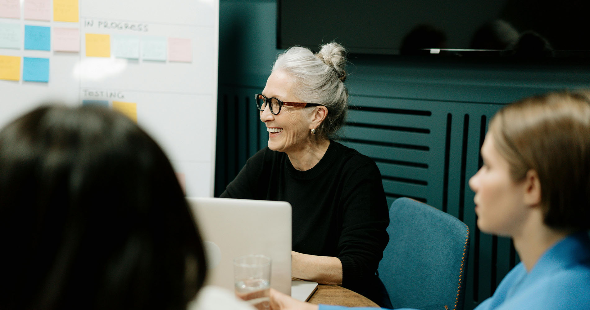 Frau leitet lächelnd ein Team-Meeting – steht exemplarisch für BWL Berufe wie den Change Manager im Veränderungsprozess.