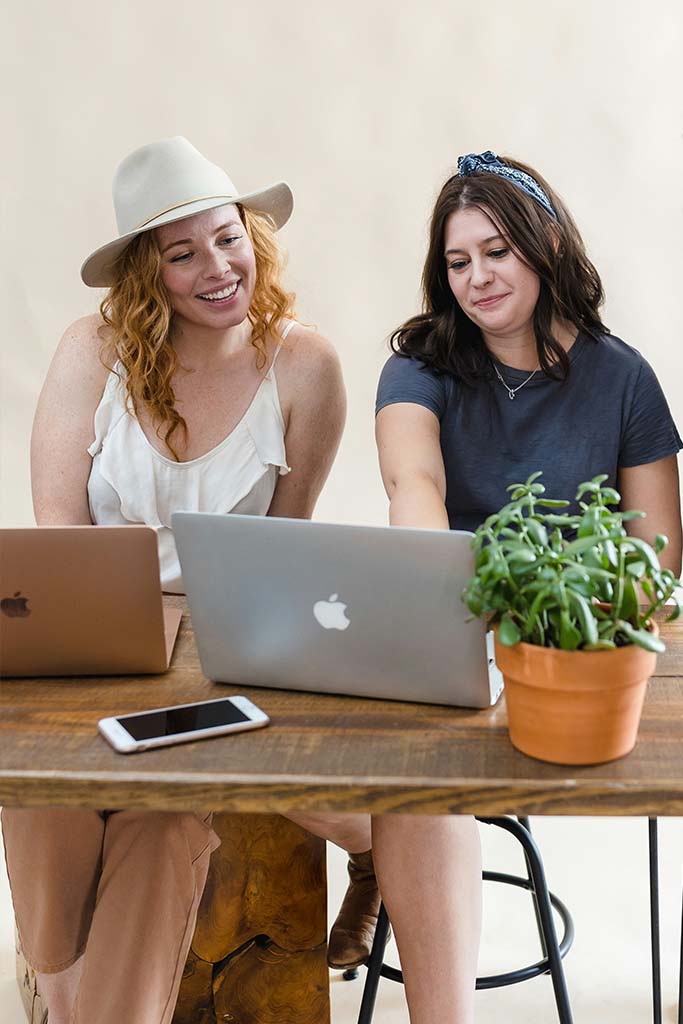 Zwei Frauen arbeiten am Laptop – kreative Zusammenarbeit, wie sie in BWL Berufen als Nachhaltigkeitsmanager gefragt ist.