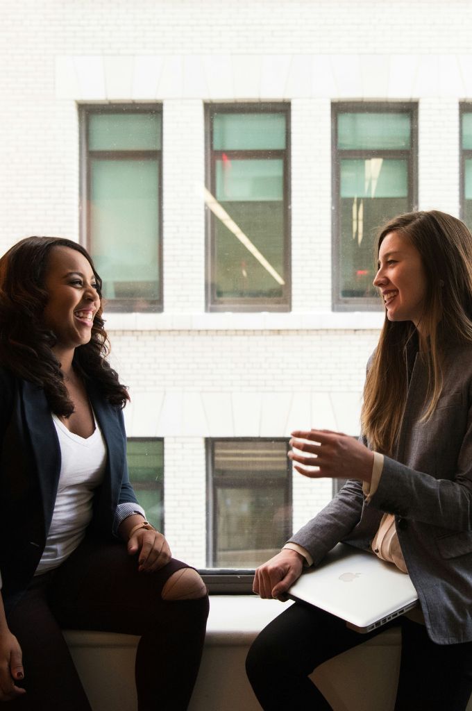 Zwei Frauen im Business-Outfit im Gespräch – Beispiel für einen Ratgeber Gehaltsverhandlung und erfolgreiche Karrieregespräche.