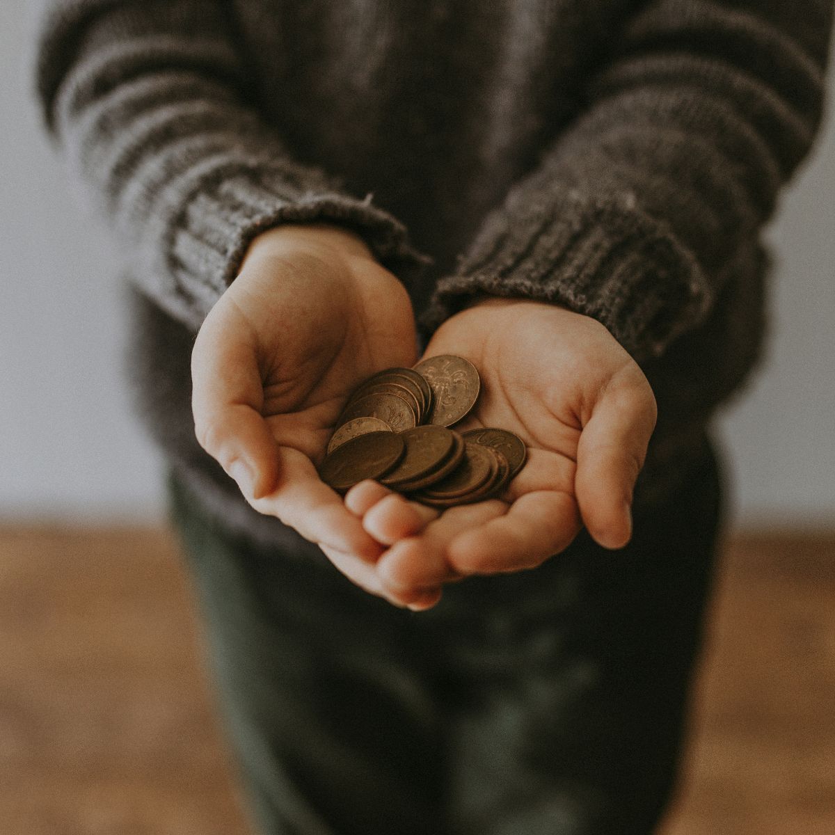 Hände halten Kleingeld & bezahlen als Symbol für einfache Ausgaben im Alltag und bewussten Umgang mit Münzen.