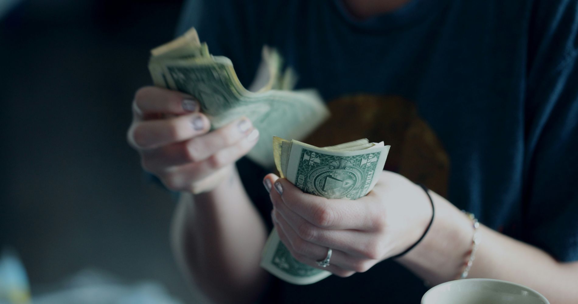 Hände zählen Dollarscheine – praktischer Alltagstipps rund um Geld & sparen für mehr finanzielle Übersicht.