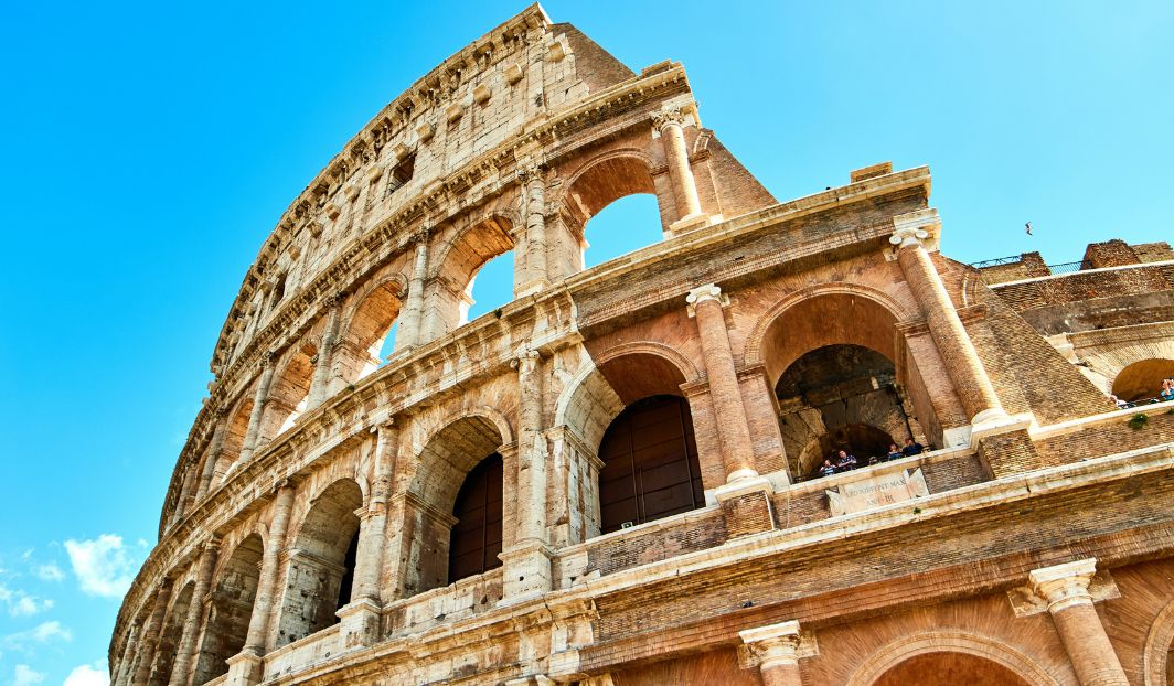 Das Kolosseum in Rom bei blauem Himmel – ein beeindruckendes Wahrzeichen für Sprachreisen nach Italien.