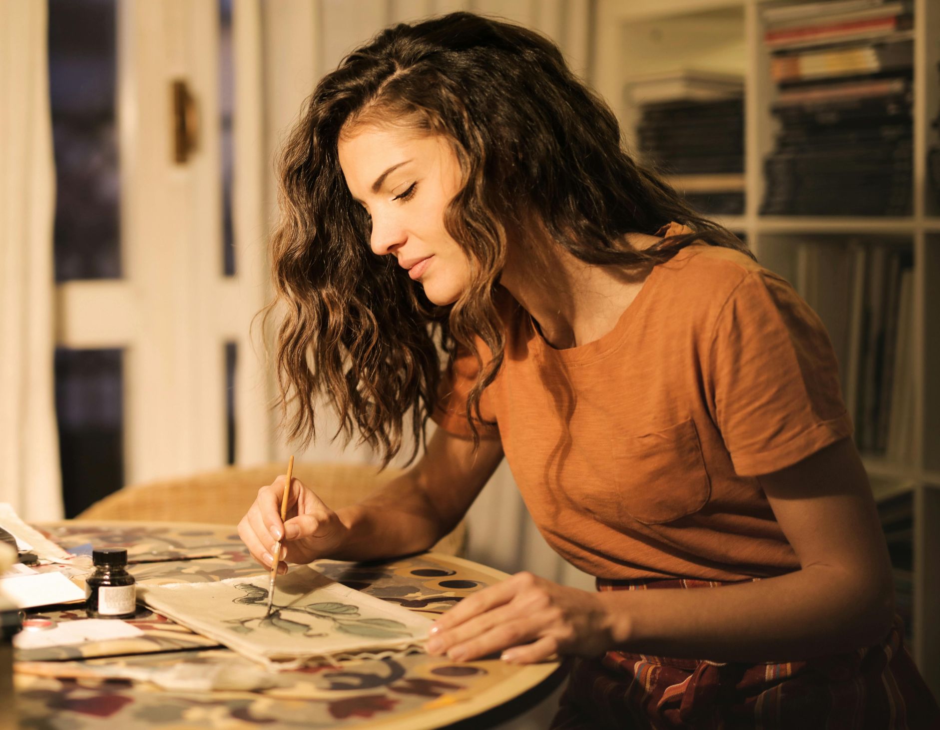 Studentin malt konzentriert an einem Kunstprojekt – ein kreatives Beispiel für den Bachelor of Art.