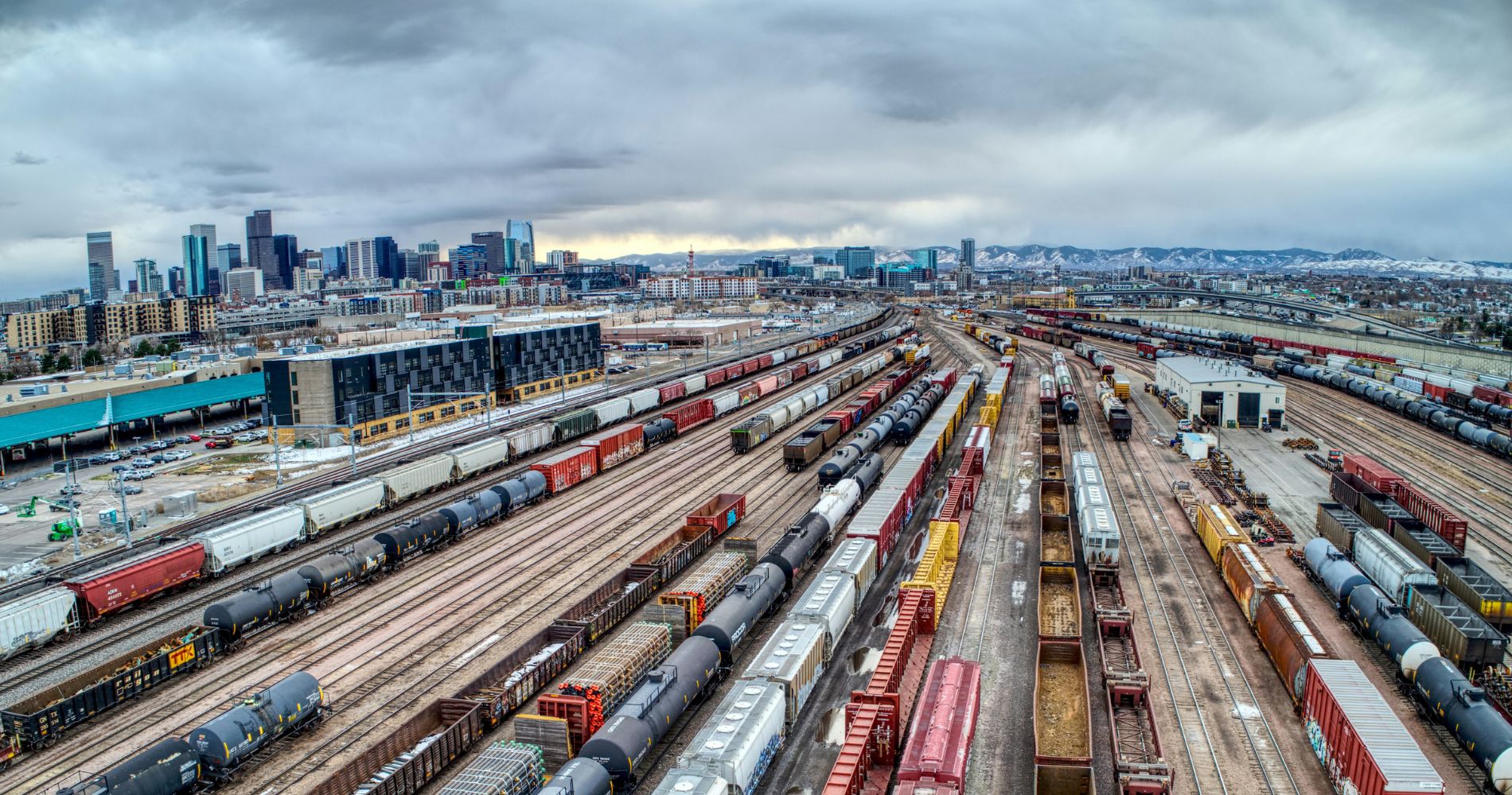 Güterbahnhof mit vielen Zügen und Containern vor Skyline – Praxisbeispiel für Logistik und Supply Chain Management Studium.