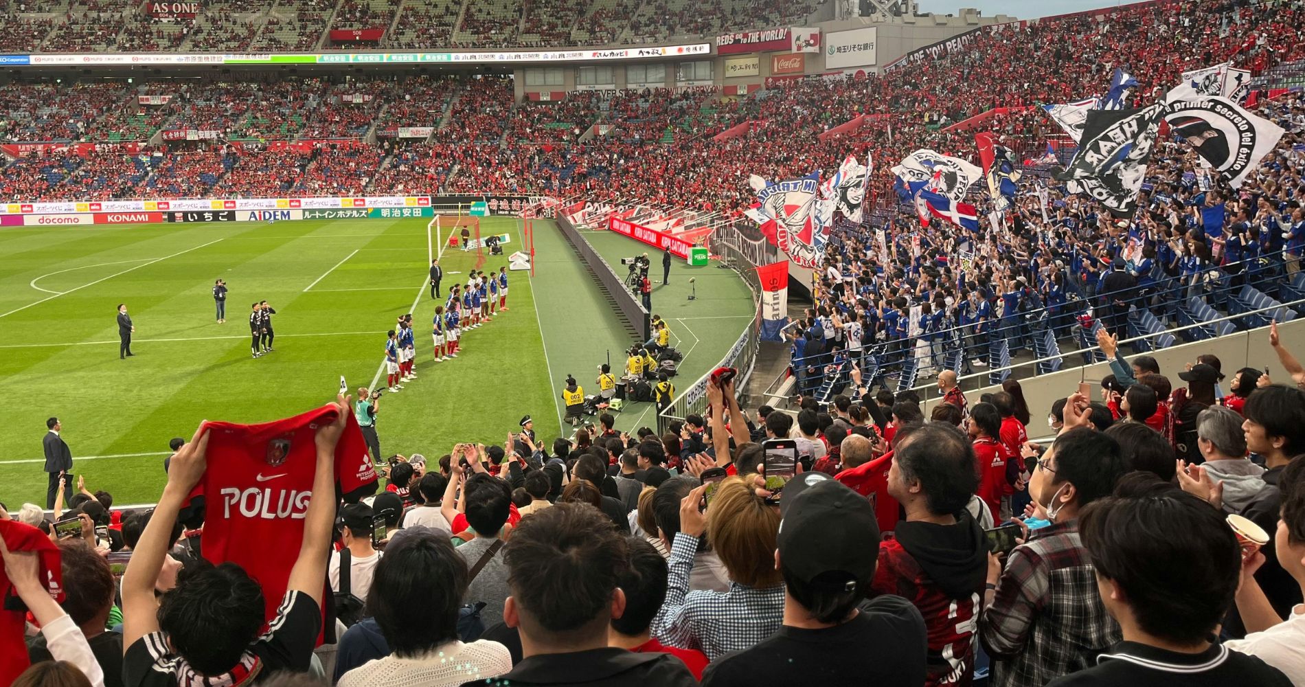 Volles Fußballstadion mit Fans und Teams am Spielfeldrand – Praxisnahes Umfeld für den Master Sportmanagement.