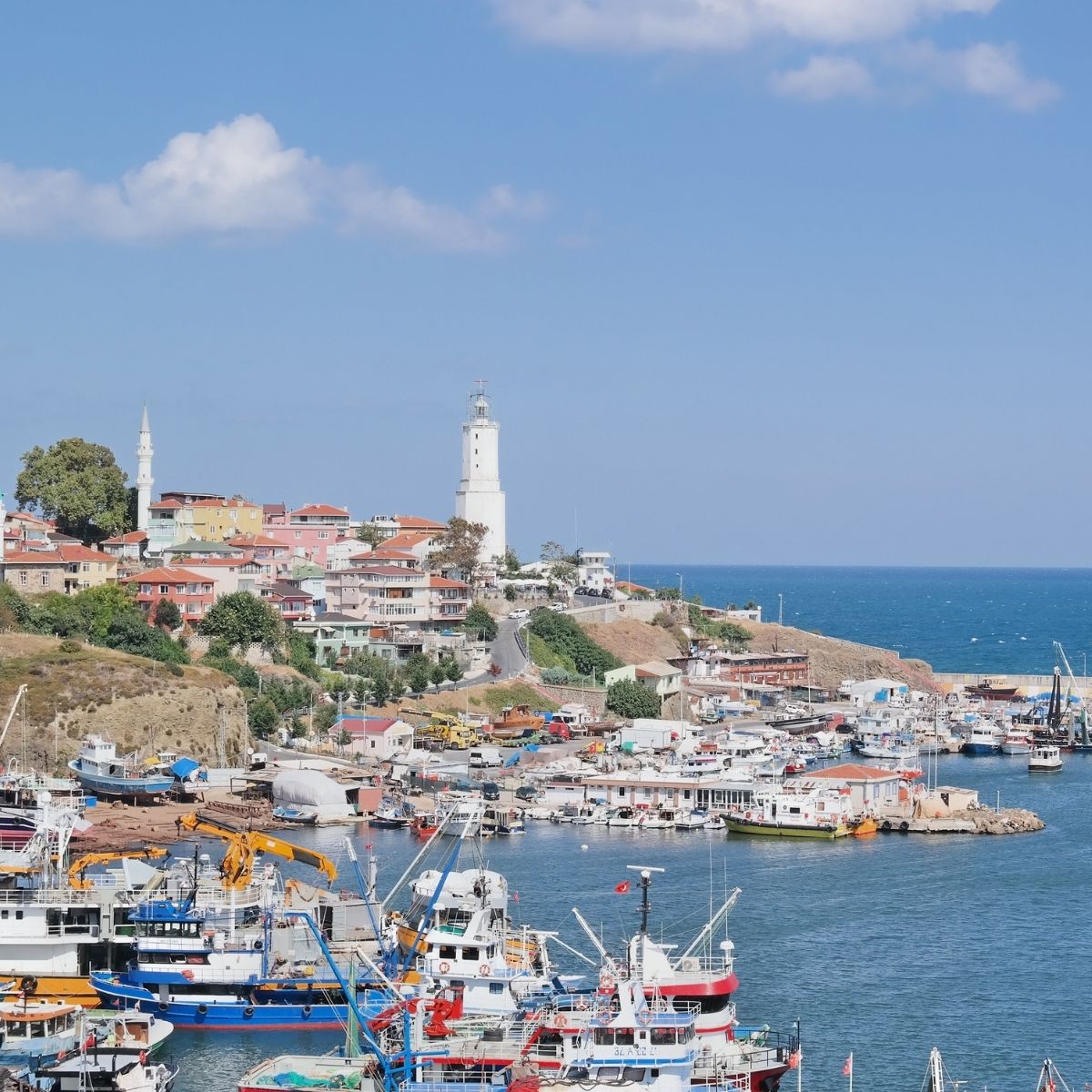 Rumelifeneri Türkei – Malerisches Fischerdorf am Schwarzen Meer mit weißem Leuchtturm und bunten Booten im Hafen.