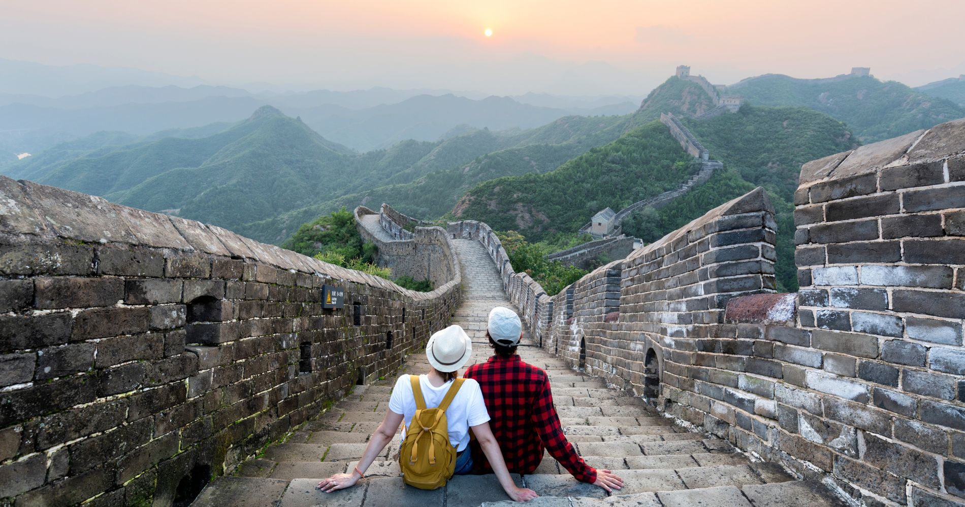 Studieren in China: Reisende auf der Chinesischen Mauer mit Blick auf die beeindruckende Berglandschaft.