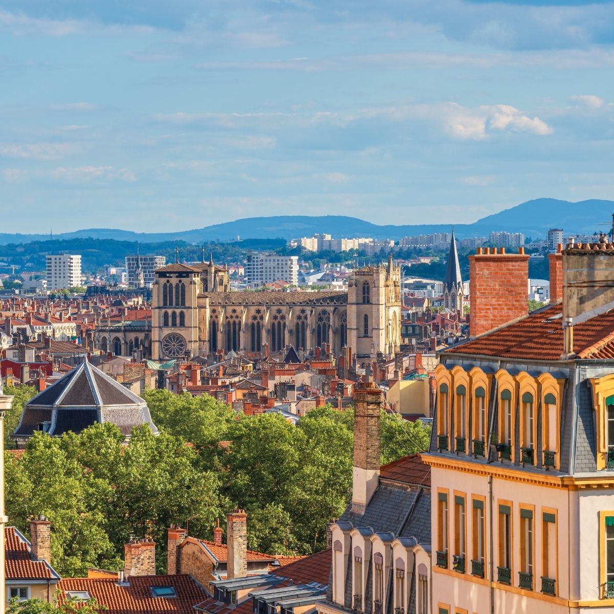 Lille – Stadtpanorama mit gotischer Cathédrale Notre-Dame-de-la-Treille und roten Ziegeldächern unter blauem Himmel.
