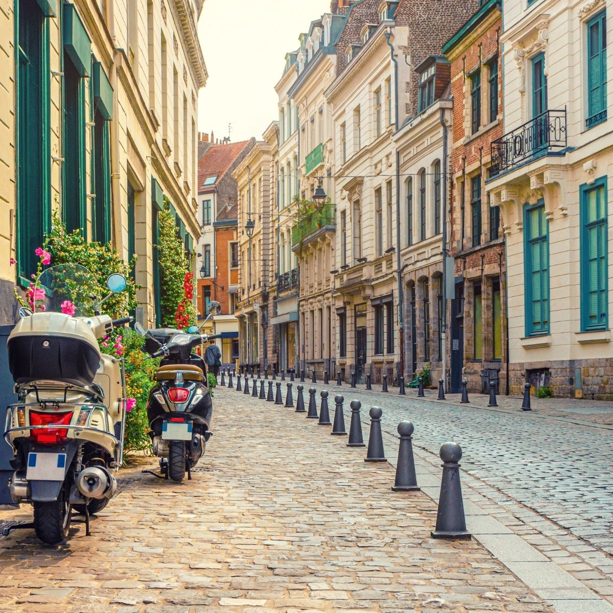 Lille – Gepflasterte Altstadtgasse mit parkenden Rollern, bunten Fensterläden und französischen Stadthäusern.