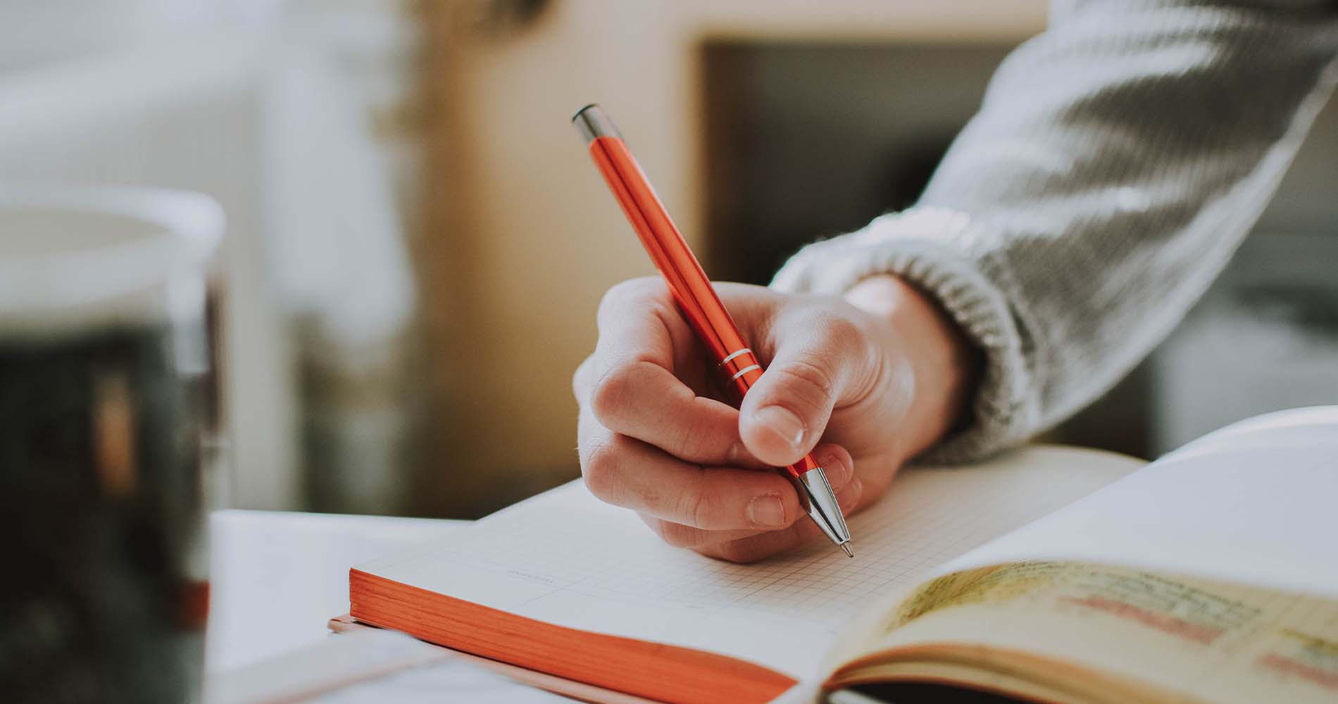 cover letter while at university Person schreibt in ein Notizbuch