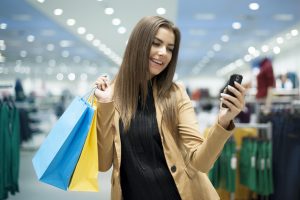 Young girl shopping with bags and cell phone in her hands