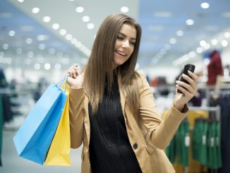 Young girl shopping with bags and cell phone in her hands