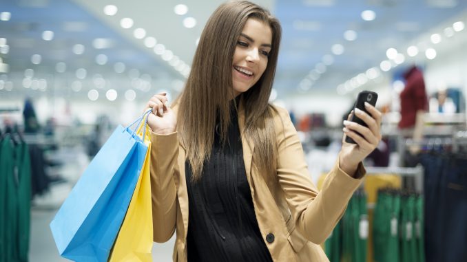 Young girl shopping with bags and cell phone in her hands