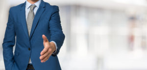 Man in suit with his hand extended forward for a handshake