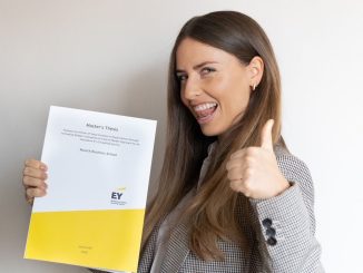 Julia Kraft, alumna of Munich Business School, with her master's thesis in hand and doing a thumbs up