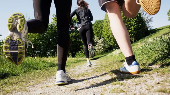 People from behind running with focus on shoes