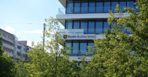 The building of Munich Business School with trees in the foreground