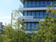 The building of Munich Business School with trees in the foreground