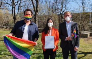 Christoph Schlottmann, Dr. Christine Menges and Prof. Dr. Stefan Baldi with the signed Diversity Charter and Pride flags in the garden of Munich Business School.