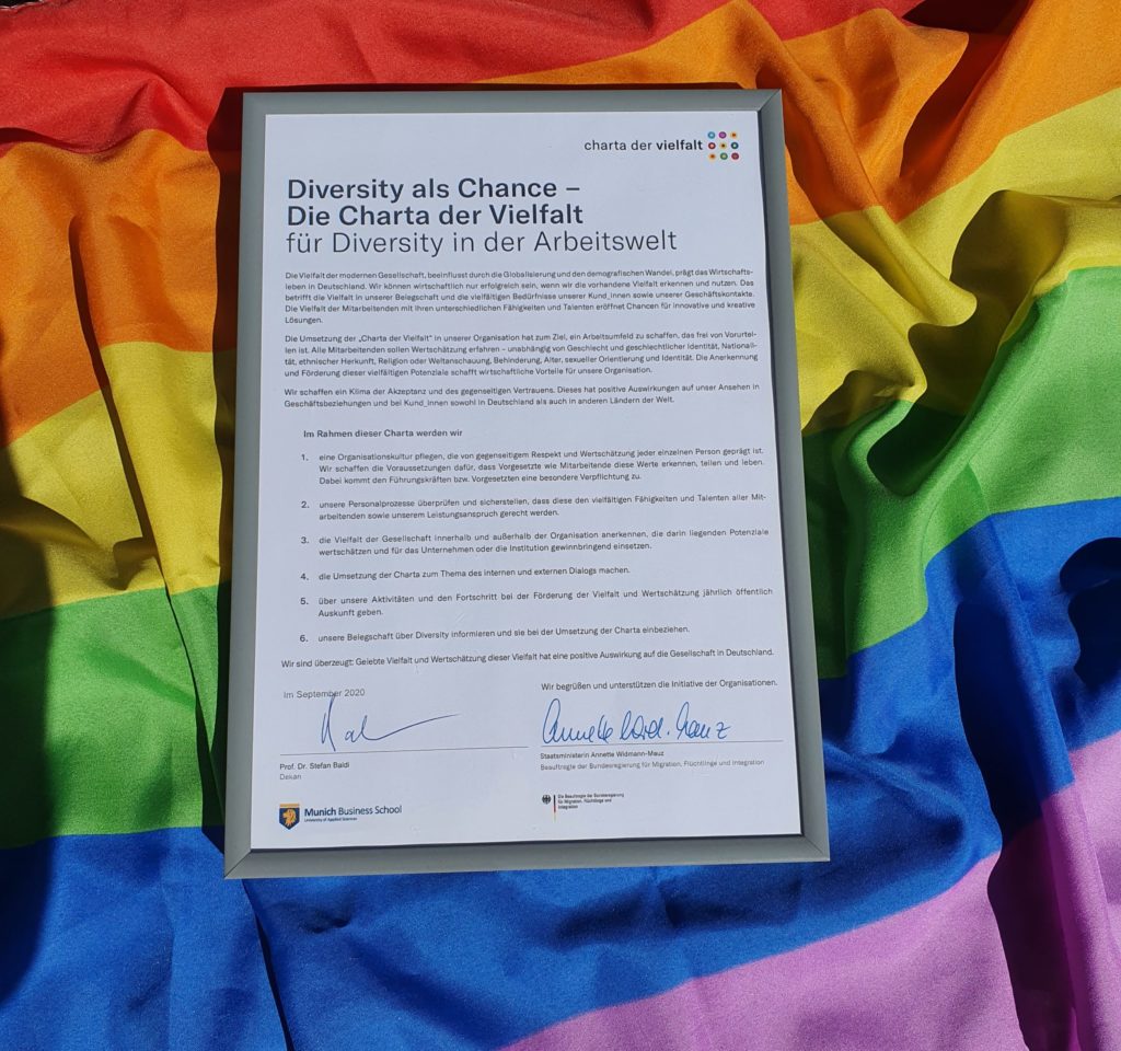 Signed Diversity Charter of Munich Business School lying on a pride flag