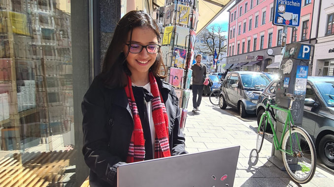 Nadja Donderer sitting outside and looking into her laptop during her online semester abroad at ISB Dublin