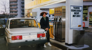 Jana Ribisch, alumna of Munich Business School, with her Wartburg car at the gas station