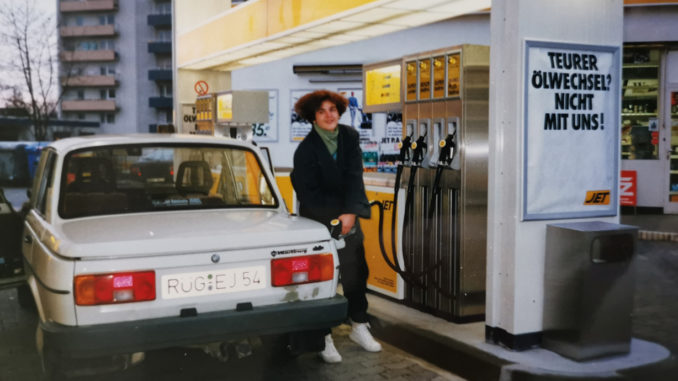 Jana Ribisch, alumna of Munich Business School, with her Wartburg car at the gas station