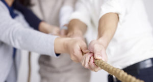 group of business people playing tug-of-war, focus on hands