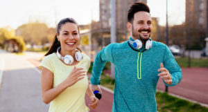 Young attractive couple running outside on sunny day