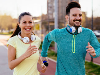 Young attractive couple running outside on sunny day