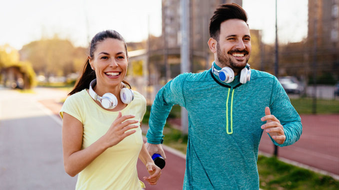 Young attractive couple running outside on sunny day