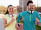 Young attractive couple running outside on sunny day