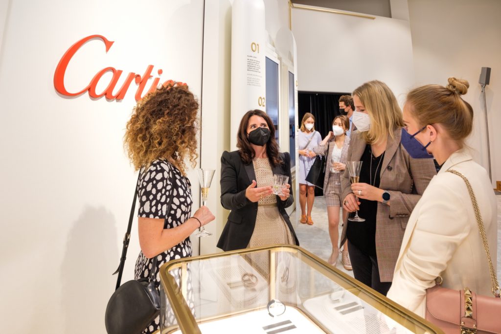 Students of Munich Business School discussing and networking at the Cartier TANK exhibition
