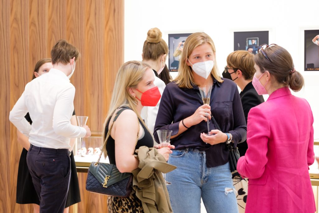 Students of Munich Business School discussing and networking at the Cartier TANK exhibition