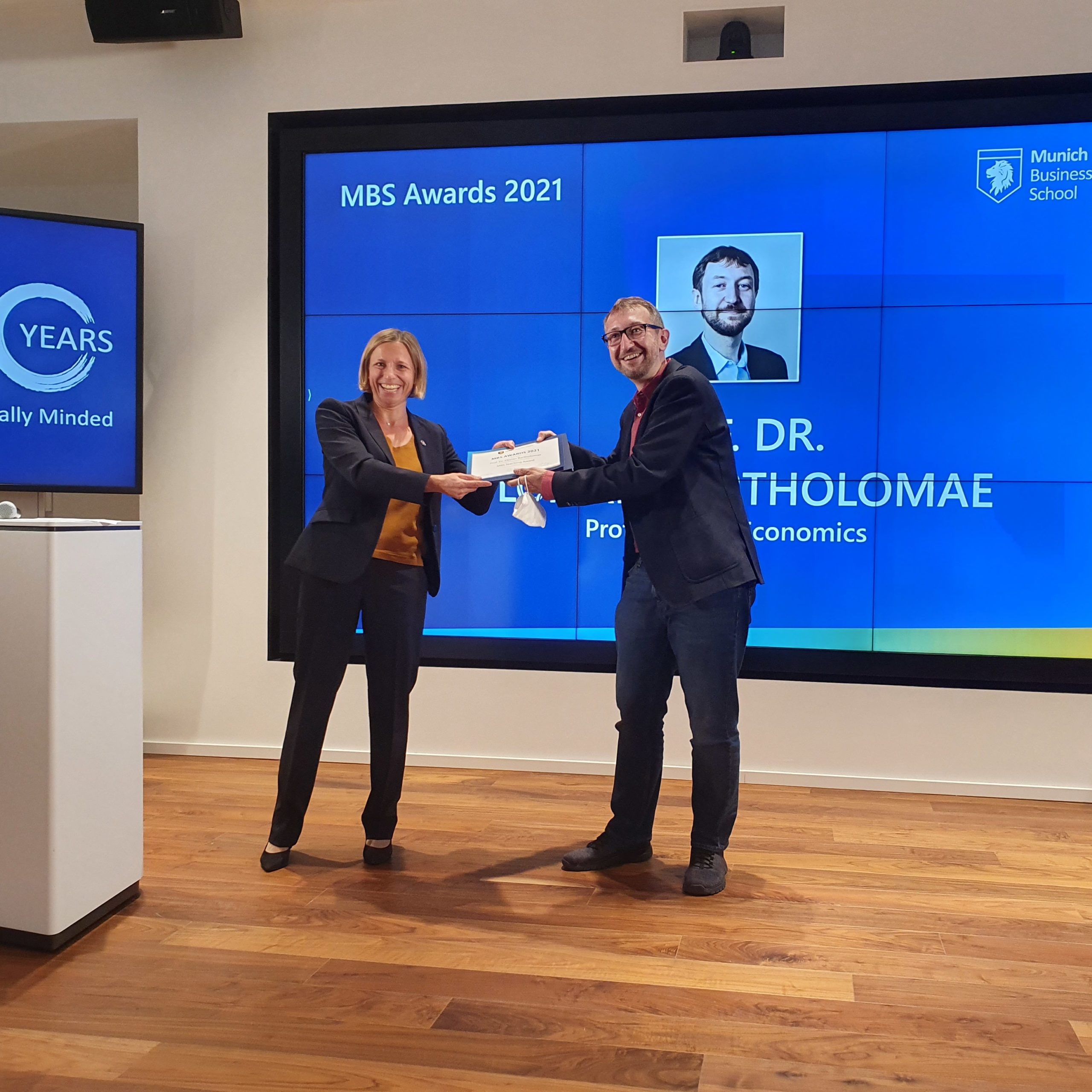 Prof. Dr. Florian Bartholomae receives MBS Teaching Award by Prof. Dr. Patricia Kraft at the semester opening ceremony 2021 of Munich Business School