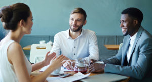 Three people sitting at a table and networking