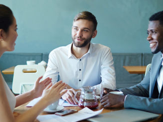 Three people sitting at a table and networking