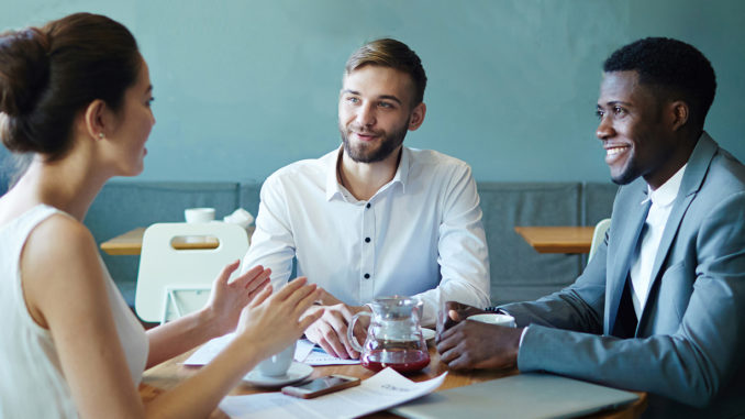 Three people sitting at a table and networking