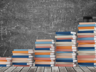 A stair made of colourful books with a graduation hat is on the final step.