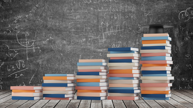 A stair made of colourful books with a graduation hat is on the final step.