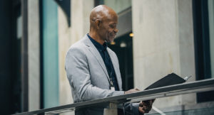 African American manager reading documents in folder.