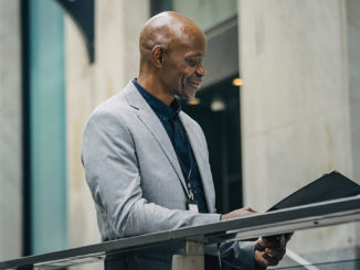 African American manager reading documents in folder.