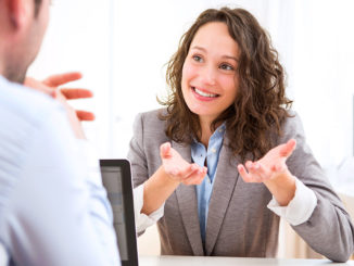 View of a young woman during a job interview answering questions.