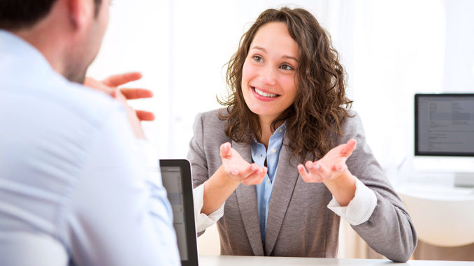 View of a young woman during a job interview answering questions.