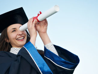 Graduate peers into the distance through the paper tube of her certificate, looking for exciting jobs after studying business