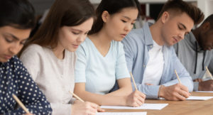 Concentrated students of different ethnicities writing an exam