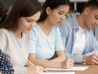 Concentrated students of different ethnicities writing an exam