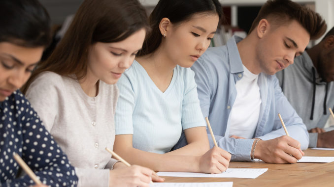 Concentrated students of different ethnicities writing an exam